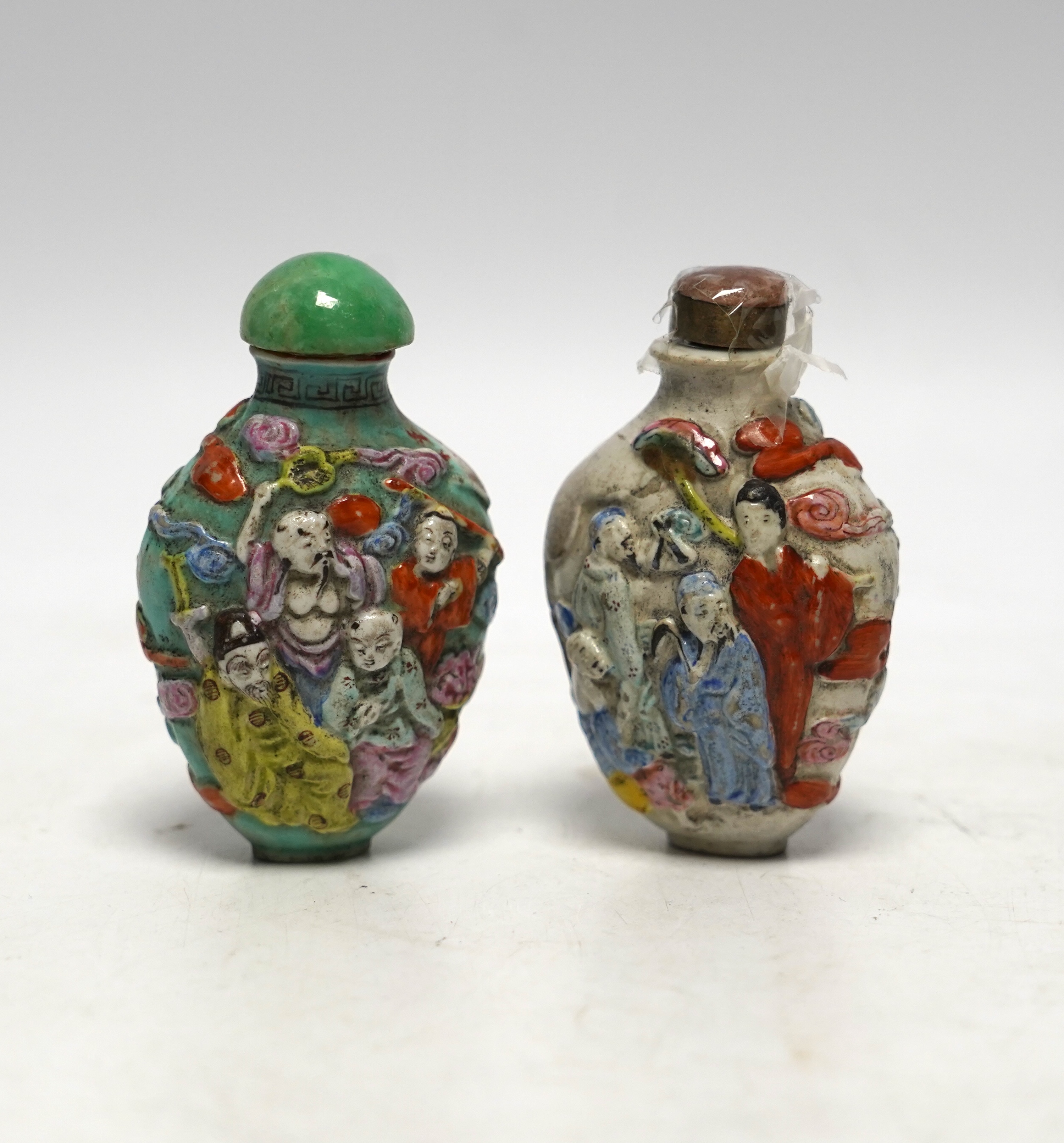 Two 19th century Chinese moulded and enamelled porcelain ’eight immortals’ snuff bottles, largest 8cm high